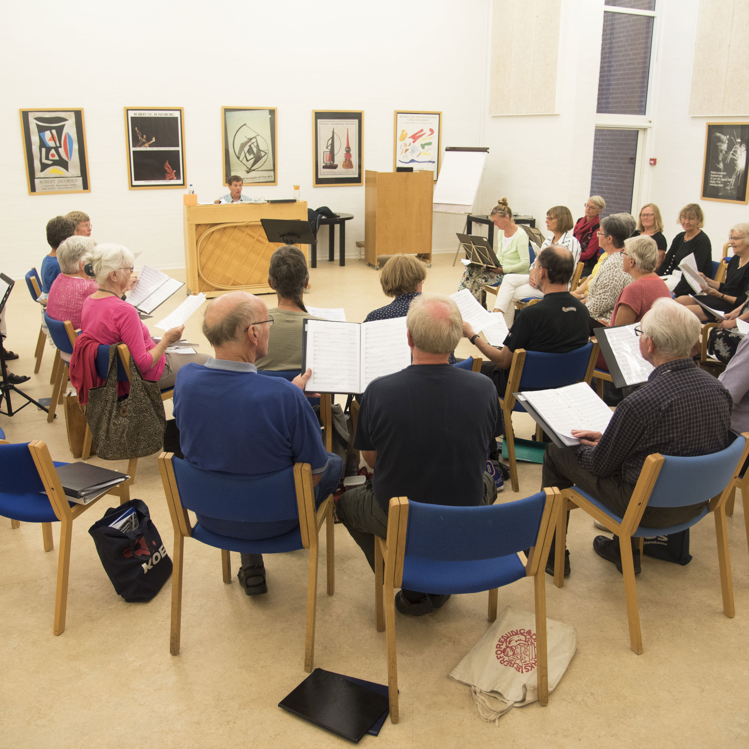 Borgere sidder i fællesskab og synger.